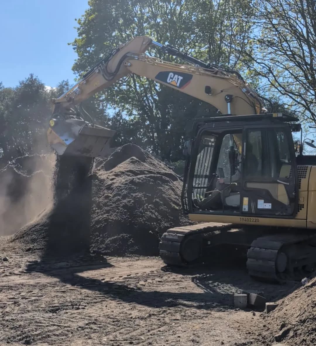 CAT-Kettenbagger von GBN Gartenbau Nord bewegt Mutterboden bei Erdarbeiten im Kreis Pinneberg