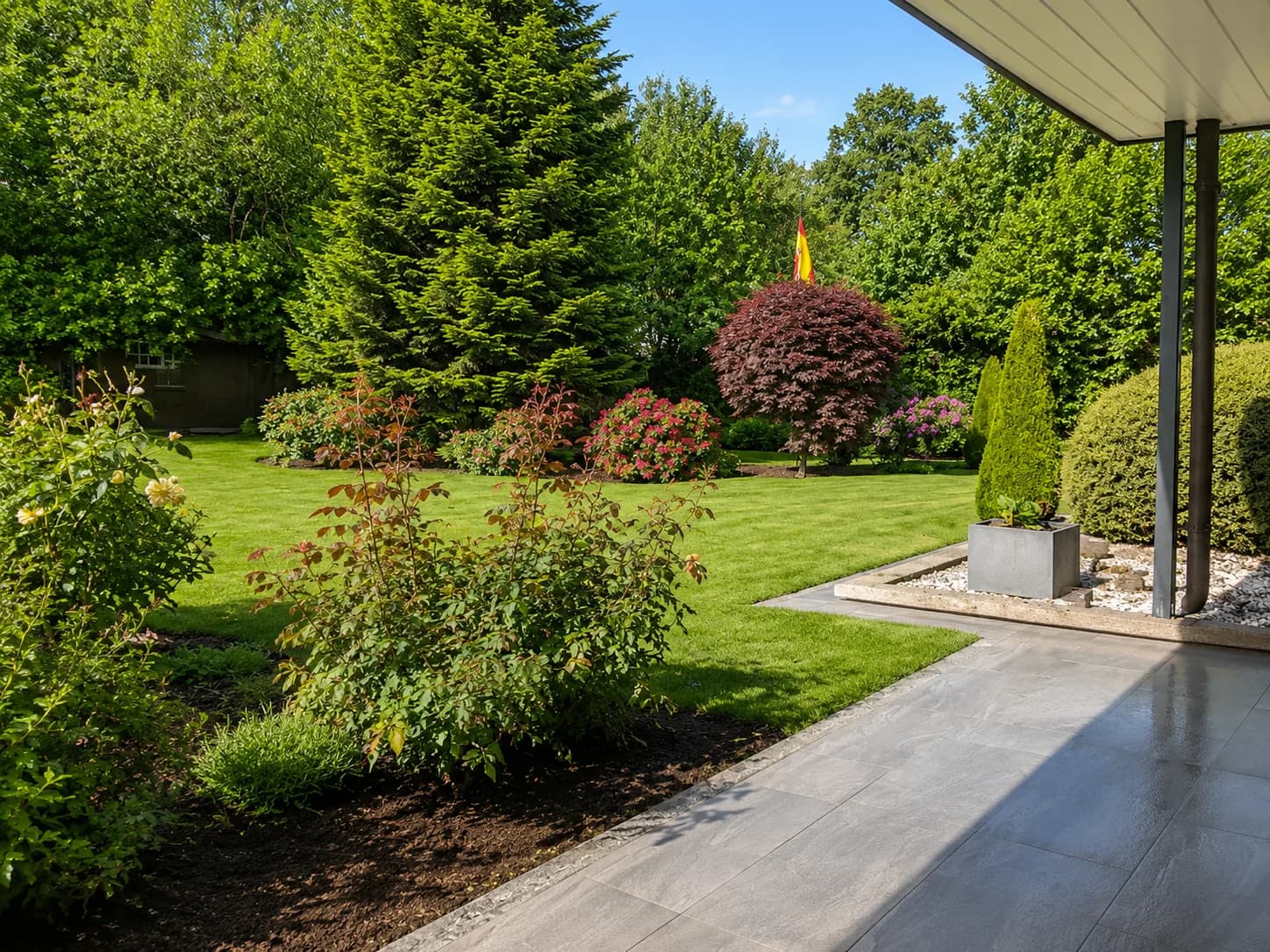 Gepflegter Garten mit Rasen, Beeten und Naturstein-Terrasse von GBN Gartenbau Nord im Kreis Pinneberg