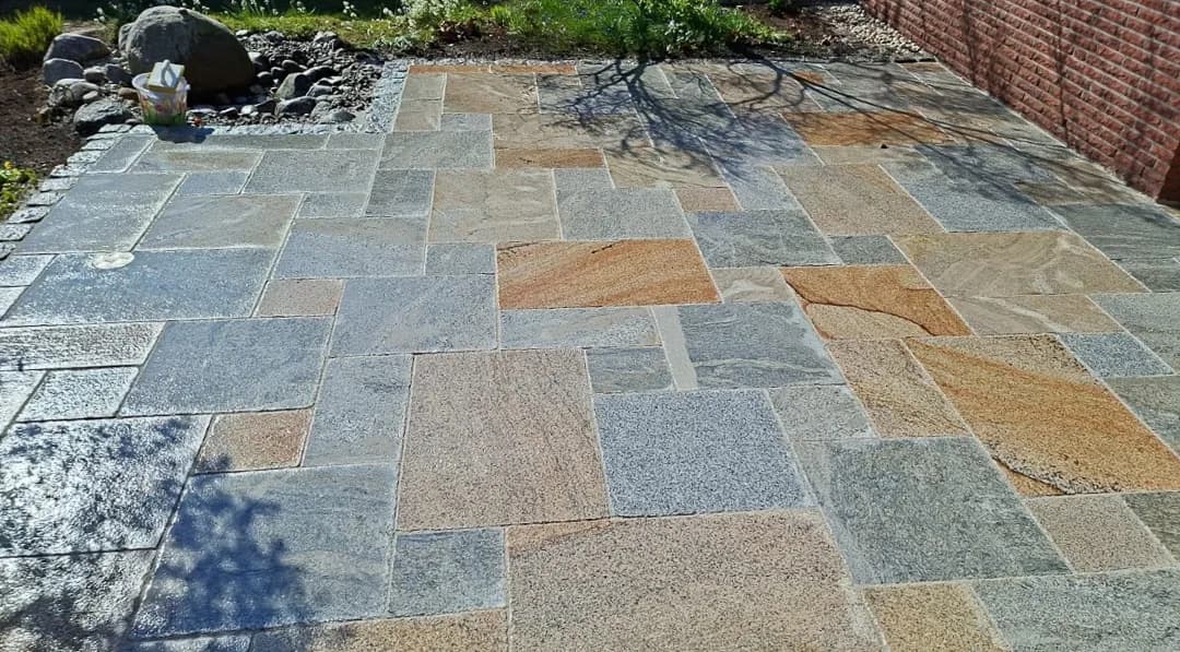 Terrasse aus mehrfarbigem Naturstein im römischen Verband im Kreis Pinneberg