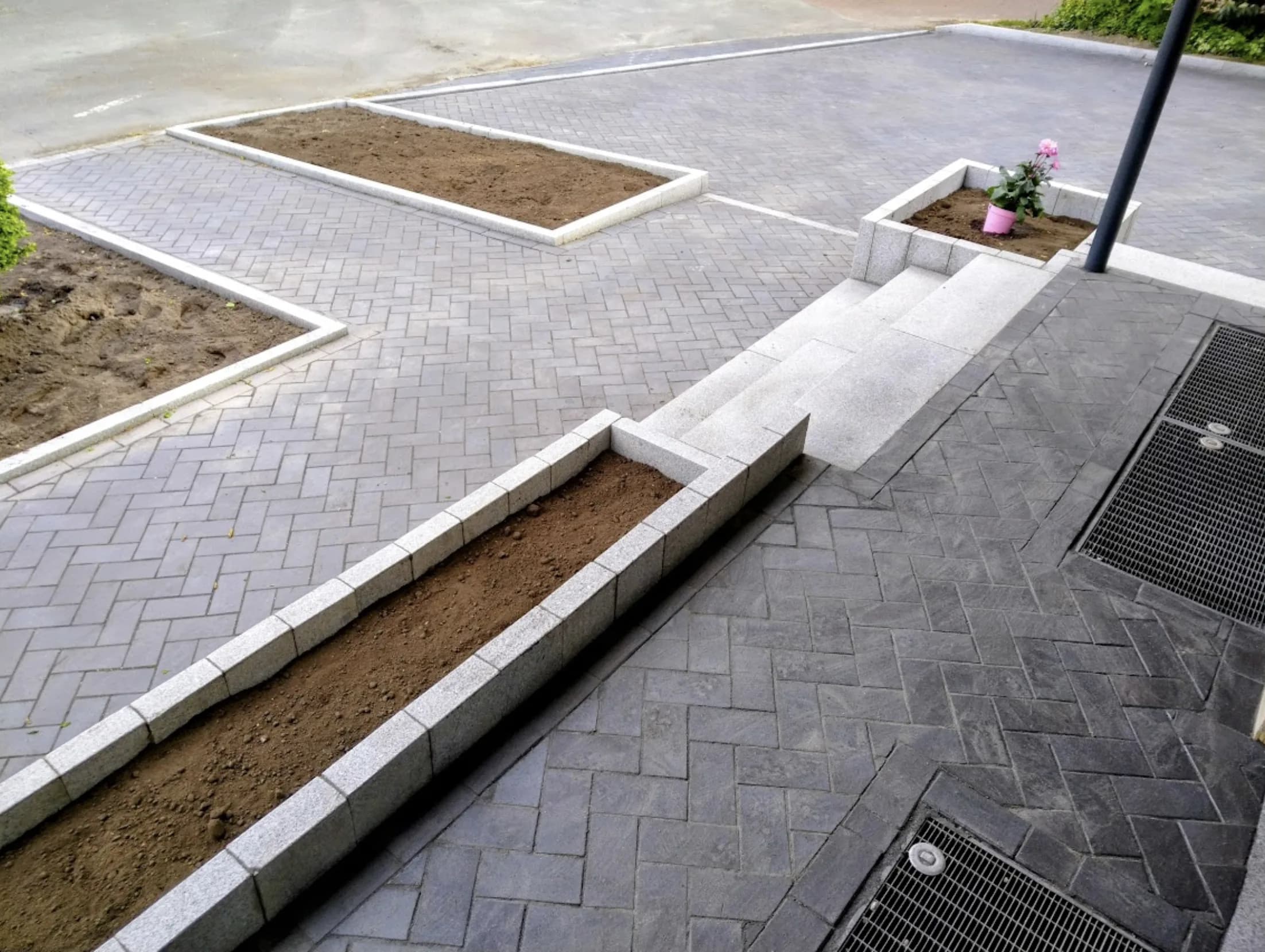 Großflächige Pflasterung in Fischgrät mit Granit-Stufen und Beeteinfassungen von GBN Gartenbau Nord im Kreis Pinneberg