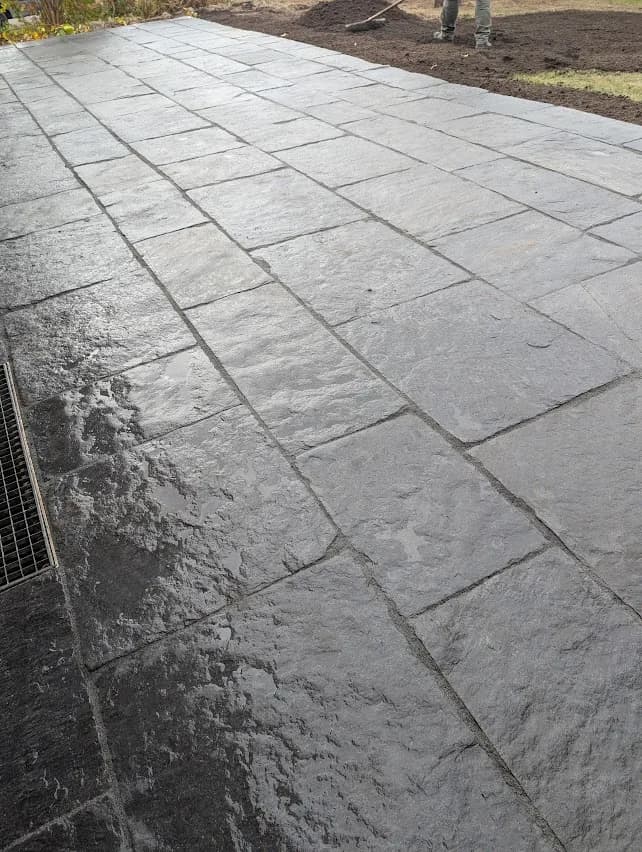 Terrasse aus dunklem Naturstein mit Bepflanzung am Wohnhaus im Kreis Pinneberg
