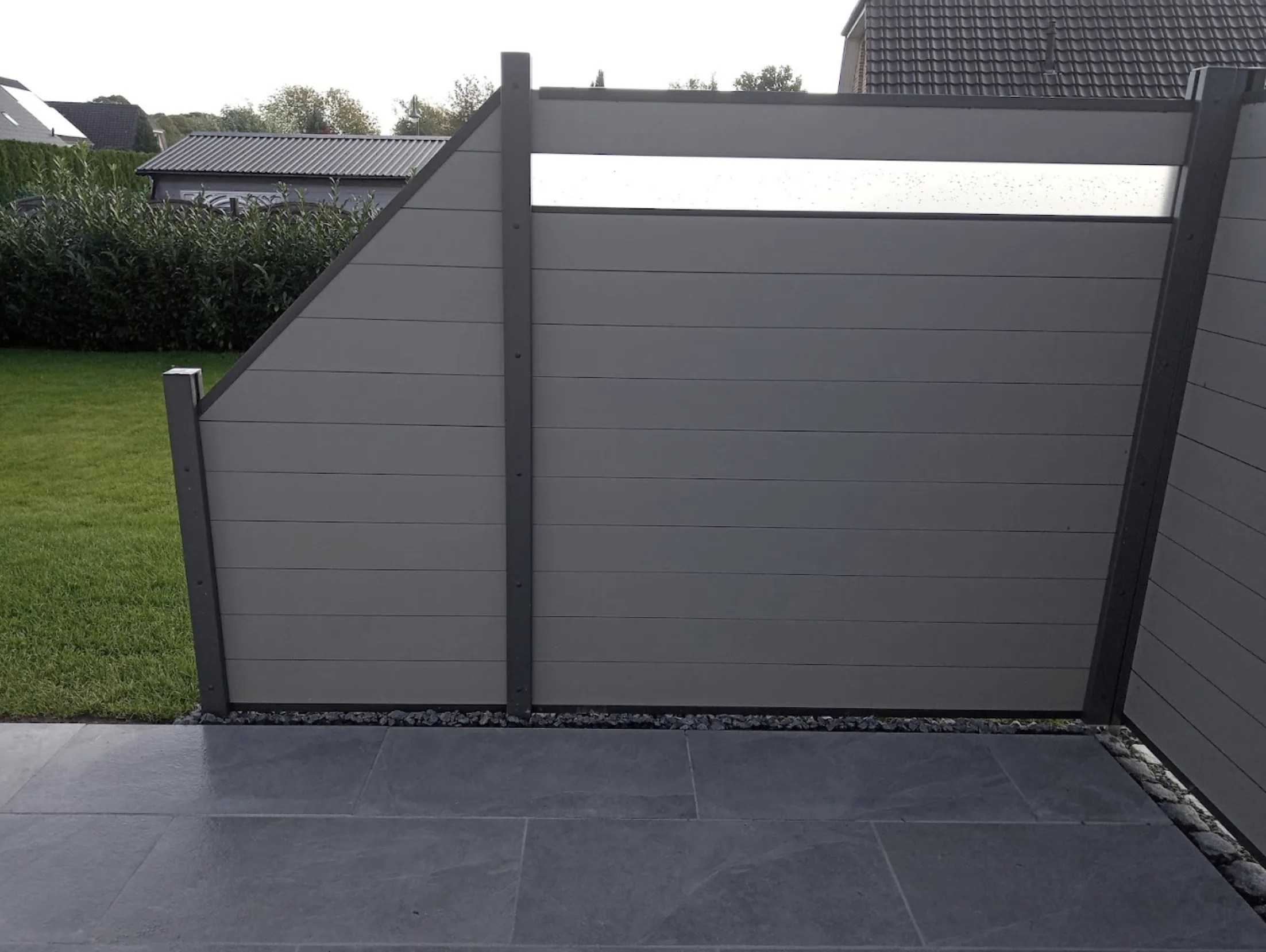 Anthrazit-Terrasse mit grauem Sichtschutzzaun und Glaselement von GBN Gartenbau Nord im Kreis Pinneberg