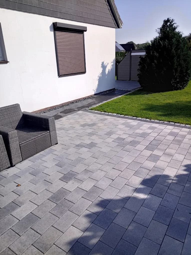 Pflasterterrasse aus grauem Betonstein mit Loungemöbeln am Wohnhaus im Kreis Pinneberg