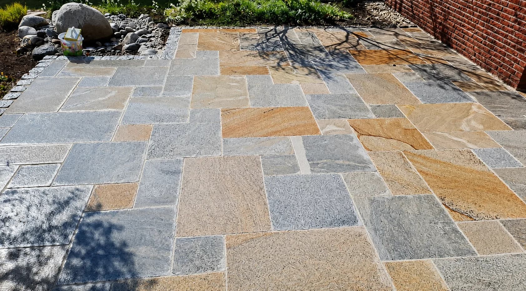 Terrasse aus mehrfarbigem Naturstein im römischen Verband, verlegt von GBN Gartenbau Nord im Kreis Pinneberg